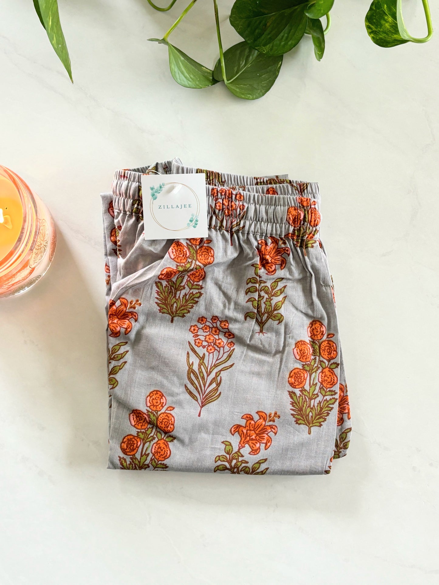 Trendy and modern 100% cotton lounge pants for women, featuring a relaxed fit and orange floral print on gray—perfect for casual lounging or a bridesmaid proposal gift.