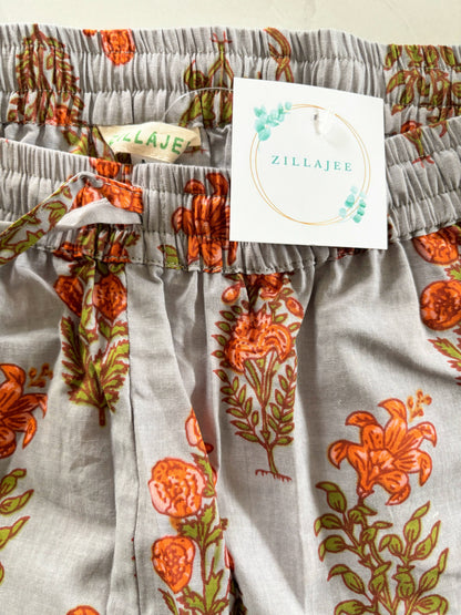 Soft and breathable pajama bottoms with pockets, designed with a trendy orange flower print on gray fabric, perfect for menopause gift ideas or everyday comfort.