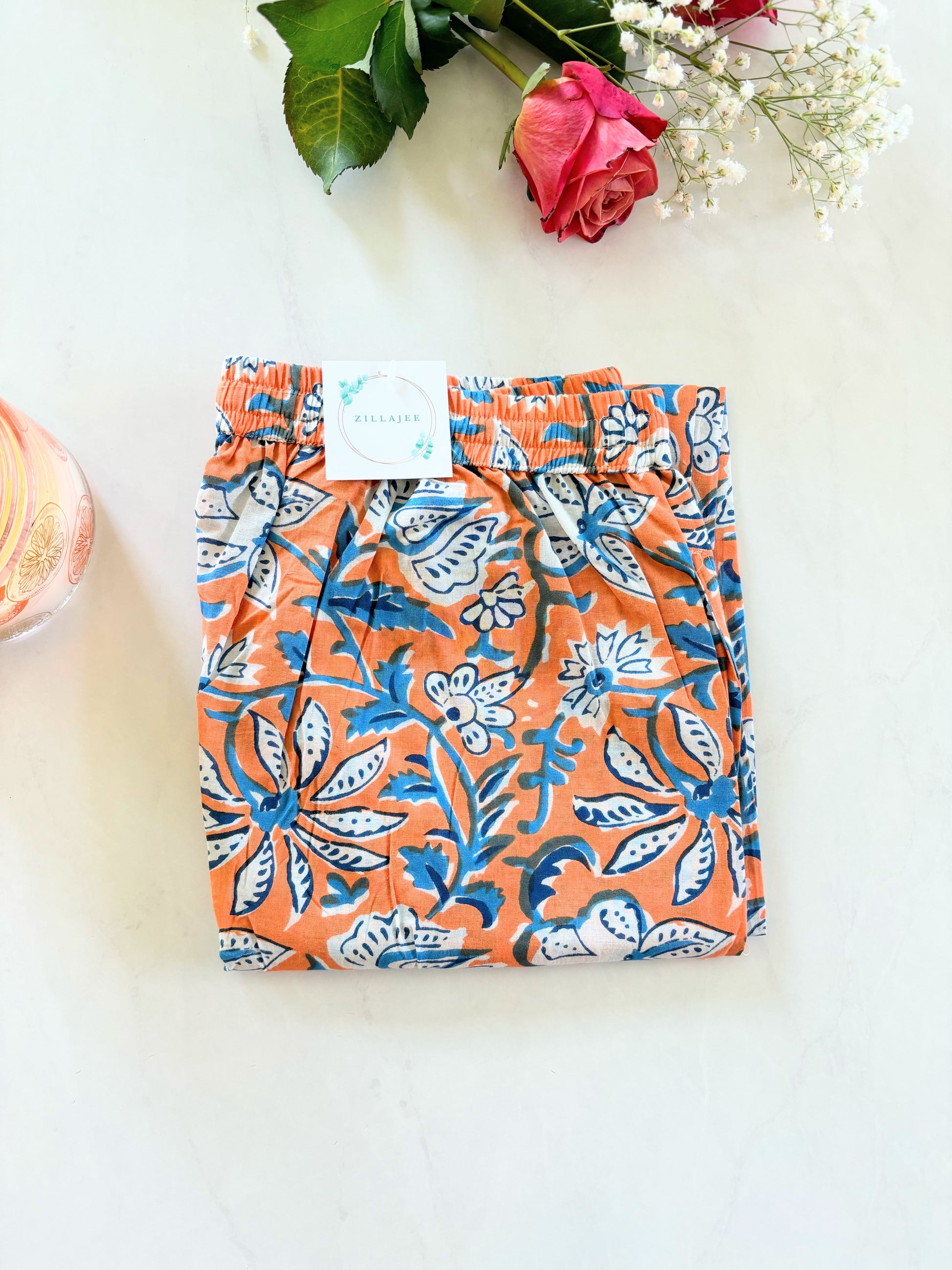 Comfy and lightweight pajama trousers for women, featuring a vibrant orange floral print on green, ideal for lounging or sleepwear.