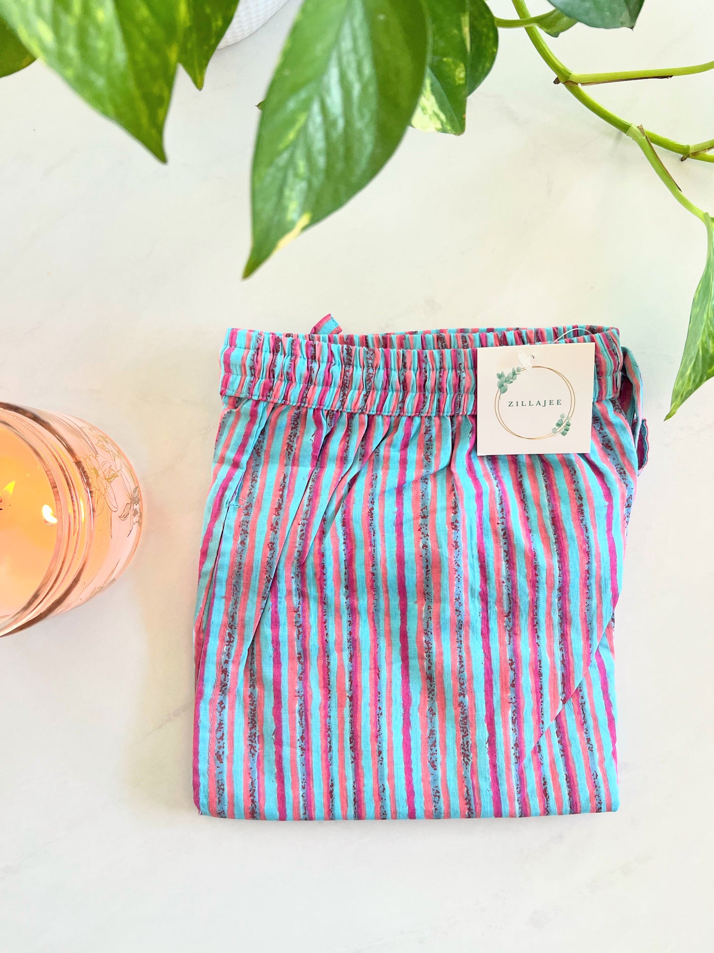 Comfortable 100% cotton pajama pants for women in a 2-pack: one pair with white flowers on a pink background, and the other with playful pink and blue stripes, both with elastic waists and pockets.