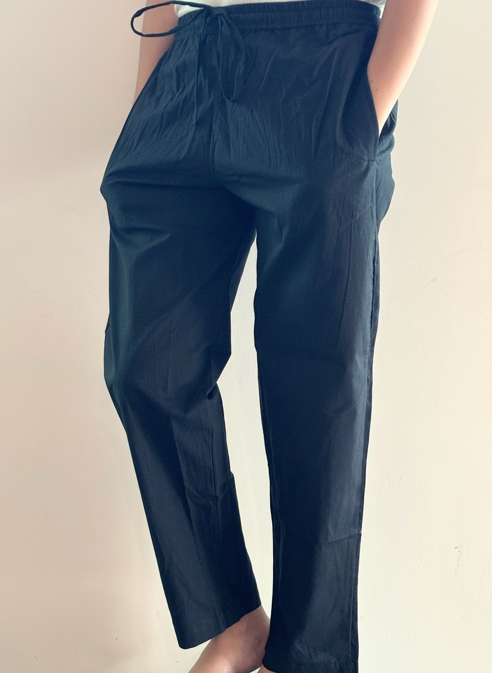 Sleek, black poplin cotton lounge pants featuring an elastic waist and side pockets, designed for ultimate comfort during sleep or casual wear