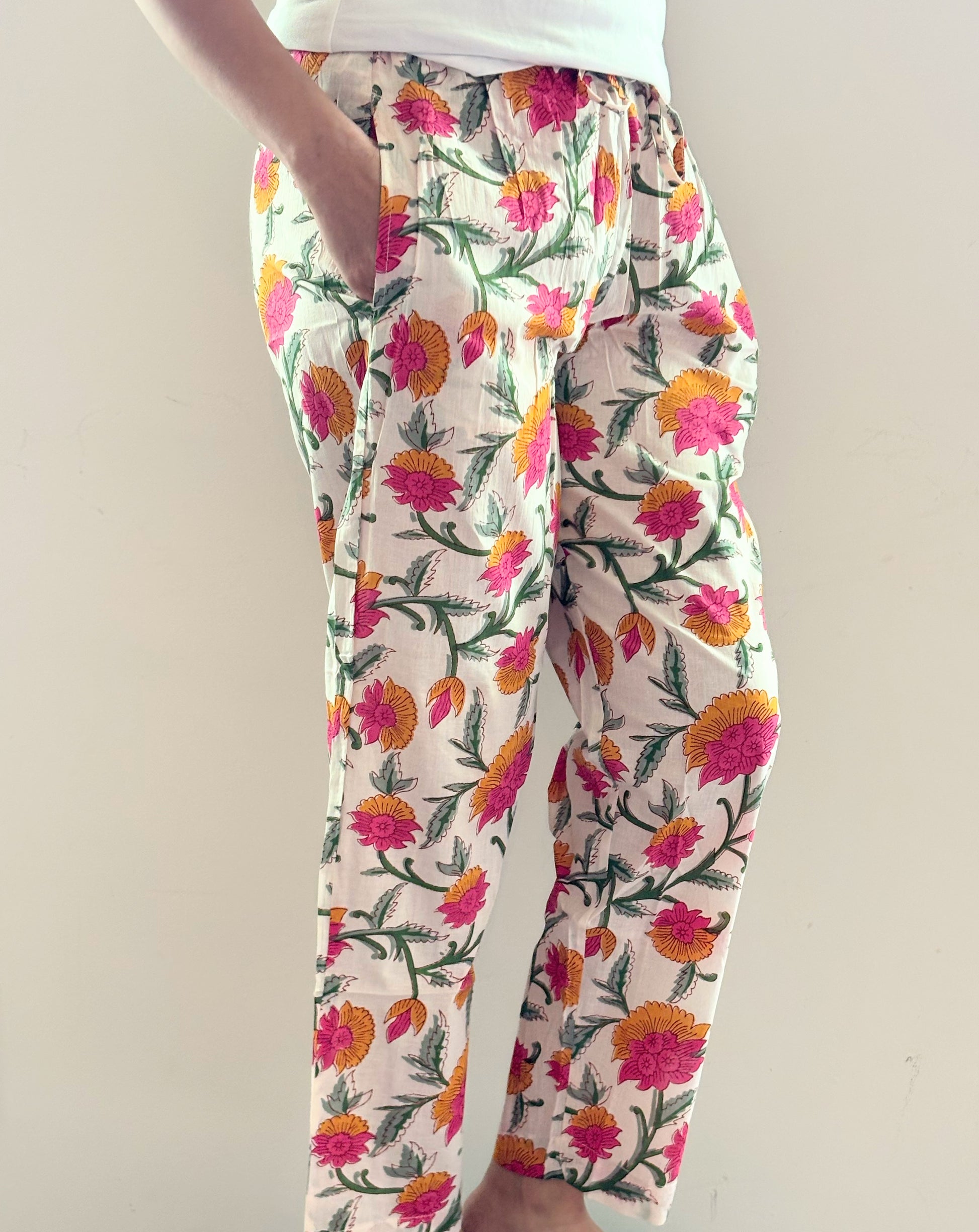 Women’s cotton lounge pants with pink and orange flowers on white background, elastic waist, and pockets