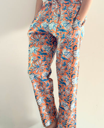 Relax in style with these ladies’ pajama pants, featuring an elastic waistband, pockets, and a beautiful orange floral print on green.