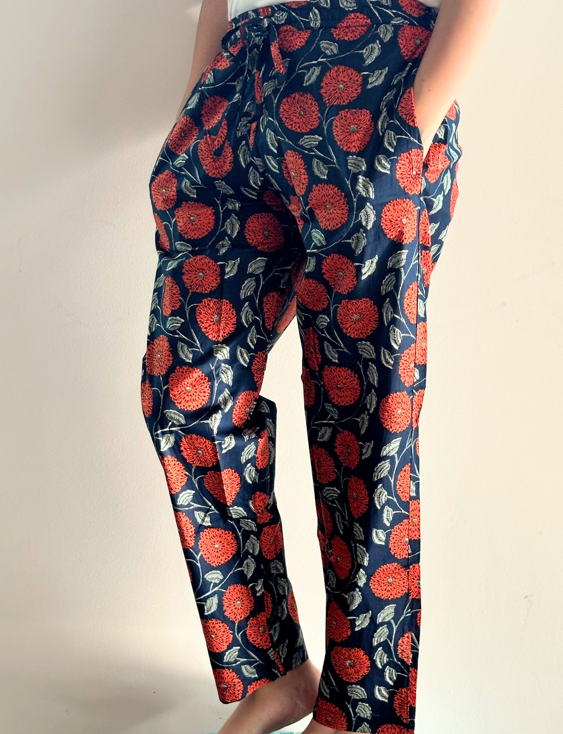 Soft and breathable 100% cotton 2-pack pajama pants for women: one pair with a yellow background and red floral print, and the other with a navy blue background and orange flowers.