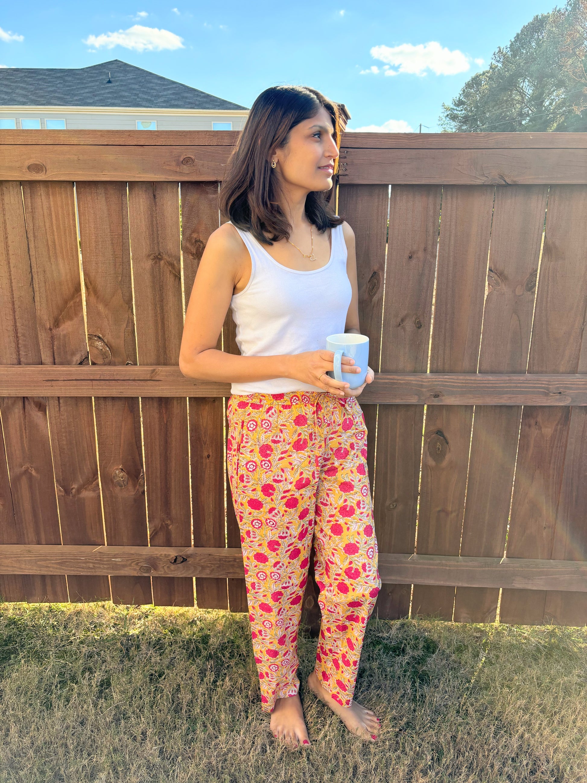 Comfortable 2-pack of women’s cotton pajama pants: one pair with red flowers on a sunny yellow background, and the other with orange flowers set against a navy blue backdrop.