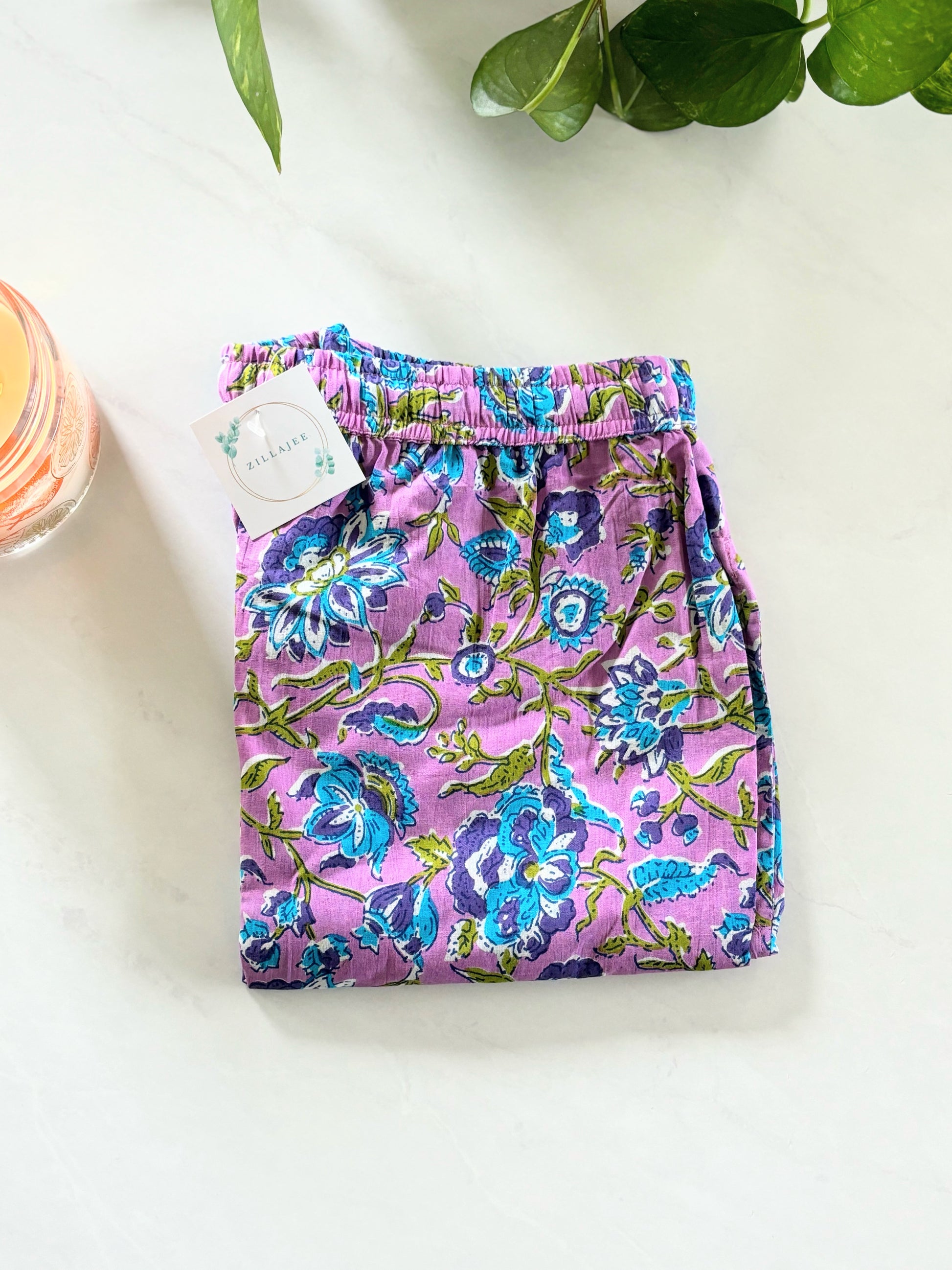 Women's 100% cotton floral pajama pants with pockets and elastic waist, featuring blue flowers on a lavender backdrop