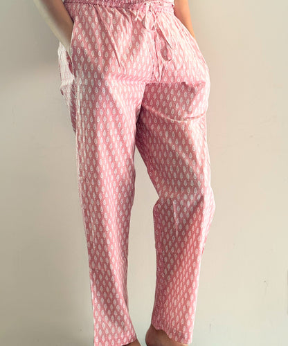 Elegant pajama bottoms for women, featuring a soft cotton fabric and a charming pink background with tiny white trees—perfect for lounging in comfort.