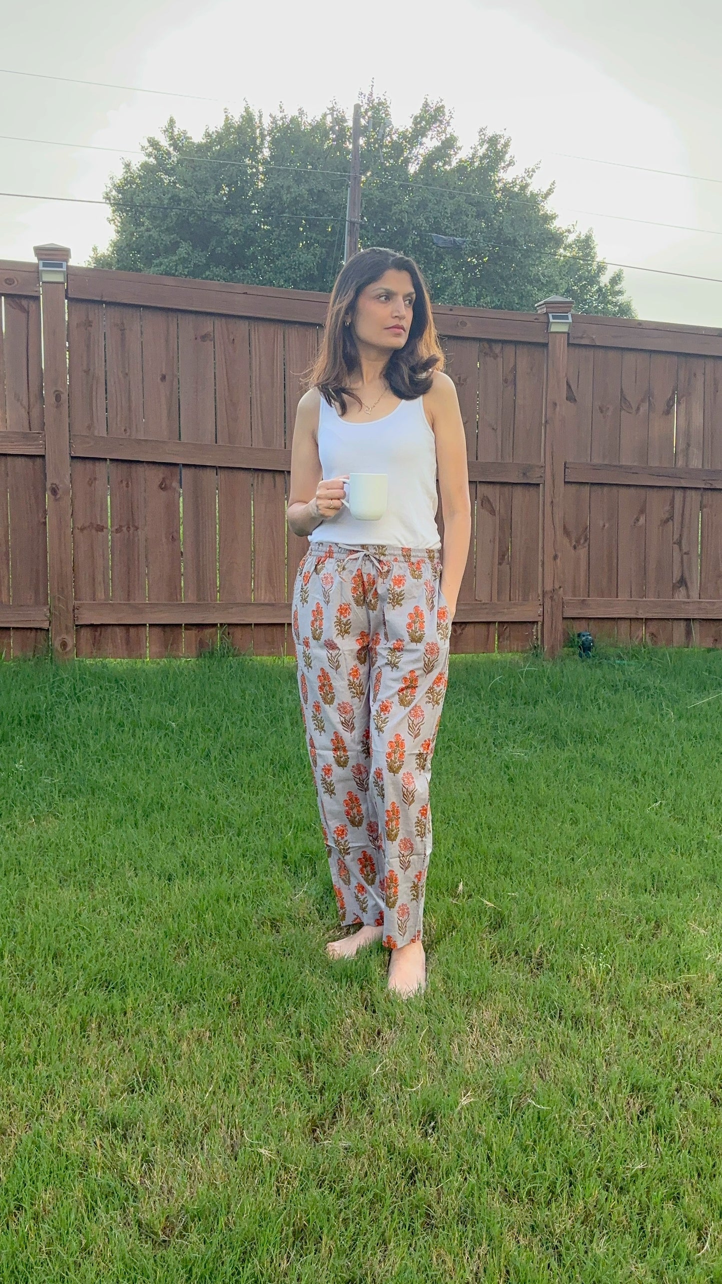 Comfortable 100% cotton pajama pants for women with an elastic waistband, drawstring, and a colorful orange flower print, perfect for lounging and sleepwear.