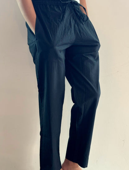 Versatile solid black poplin cotton lounge pants for women, complete with an elastic waistband and side pockets, perfect for yoga, lounging, or sleeping