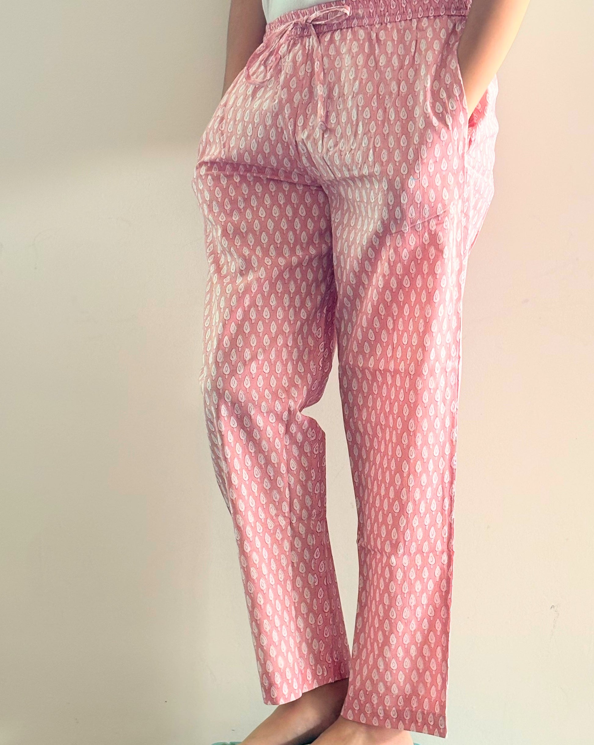 Comfortable pajama trousers for ladies, featuring a cute print of small white trees on pink, ideal for restful sleep or cozy evenings at home.