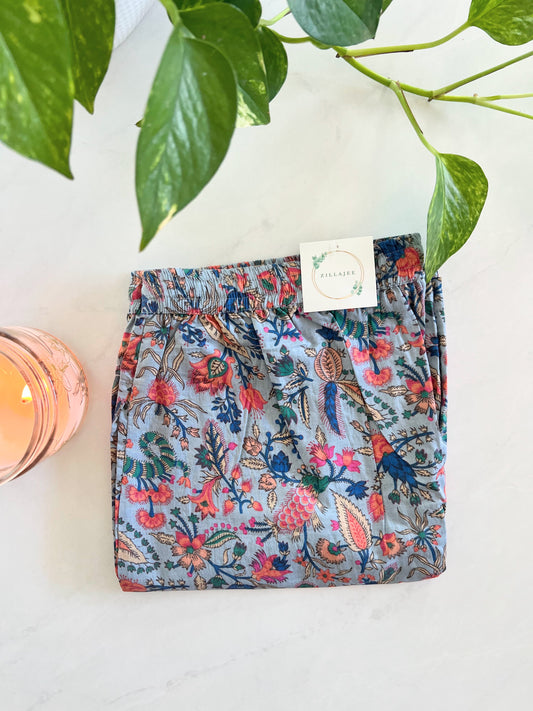 Elegant women’s 100% cotton pajama bottoms with a floral print of pink flowers on gray, featuring an elastic waistband and pockets—soft, breathable, and eco-friendly.